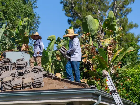 Crew removing old roof tile