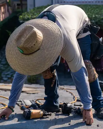 Crew member nailing shingles